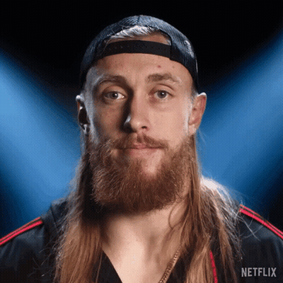 Man With Long Hair And Beard In Netflix Hat And Shirt GIF