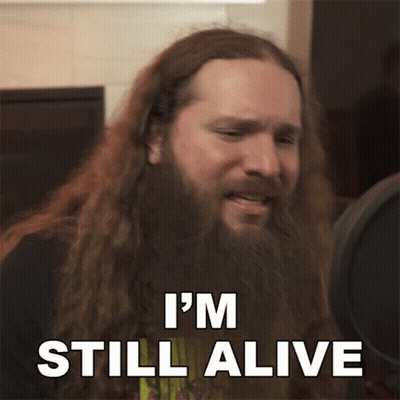 Man With Long Hair And Beard Saying I'm Still Alive GIF