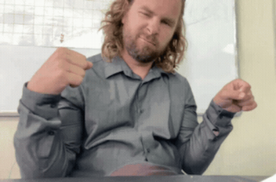 Man With Long Hair And Beard Sitting At Desk GIF
