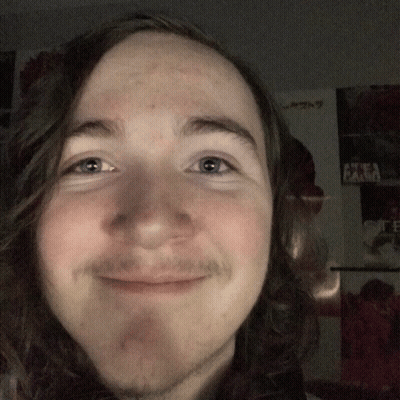 Man With Long Hair And Beard Smiling In Front Of Akira Poster GIF