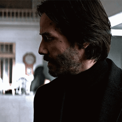 Man With Long Hair And Beard Standing In Dark Room GIF