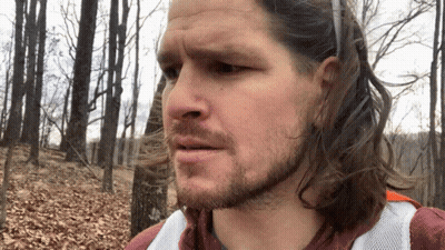 Man With Long Hair And Beard Standing In Woods GIF
