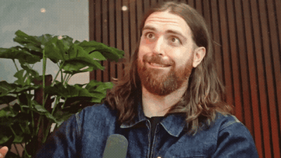 Man With Long Hair And Beard Talking Into Microphone GIF