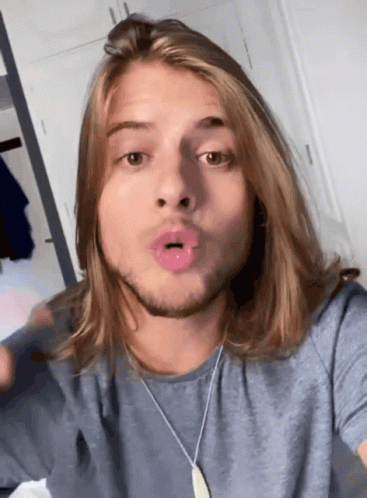 Man With Long Hair And Beard Wearing Blue Shirt And Necklace GIF
