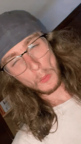 Man With Long Hair And Glasses Wearing Baseball Cap GIF