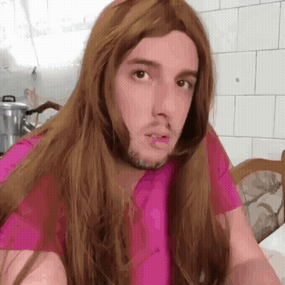 Man With Long Hair And Pink Shirt Making Funny Face GIF