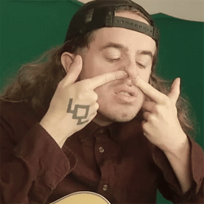 Man With Long Hair And Tattoo Holding Nose GIF