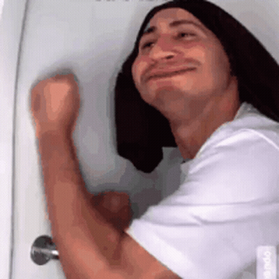 Man With Long Hair And Towel On Head Standing In Front Of Door GIF