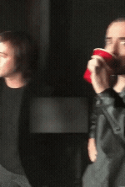 Man With Long Hair Drinking From Red Cup GIF