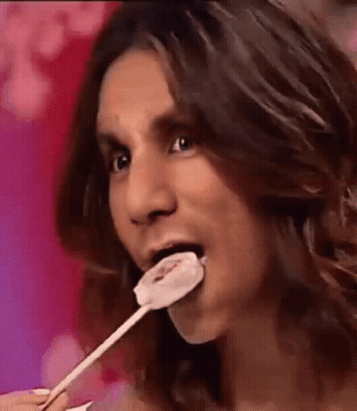 Man With Long Hair Eating Lollipop GIF