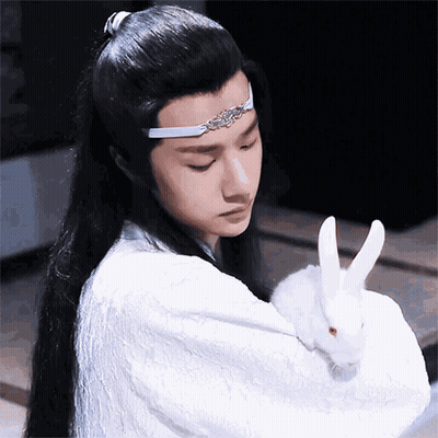 Man With Long Hair Holding White Rabbit GIF