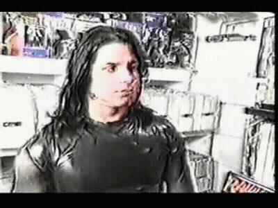 Man With Long Hair In Front Of Clothes Shelf GIF