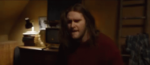 Man With Long Hair In Front Of Lamp And TV GIF