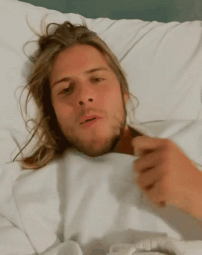 Man With Long Hair Laying In Bed GIF
