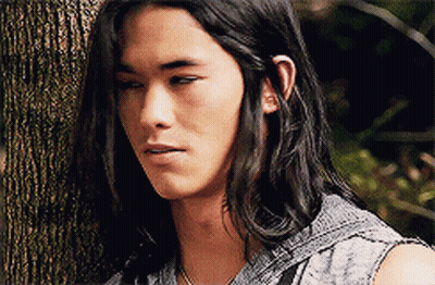 Man With Long Hair Leaning Against Tree GIF