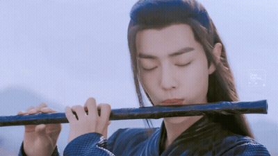 Man With Long Hair Playing Flute Blue Background GIF
