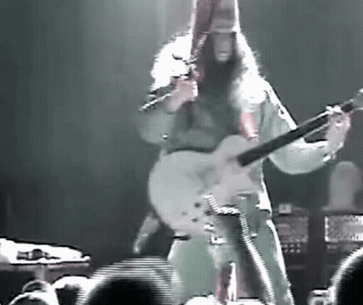 Man With Long Hair Playing Guitar On Stage GIF