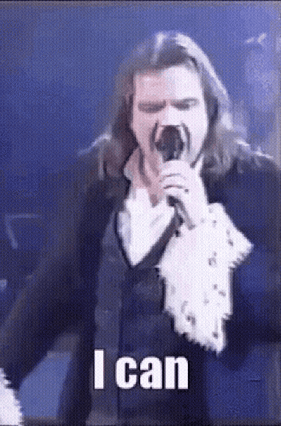 Man With Long Hair Singing Into Microphone GIF