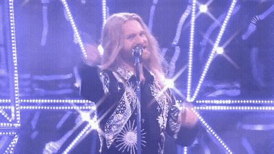 Man With Long Hair Singing Into Microphone GIF