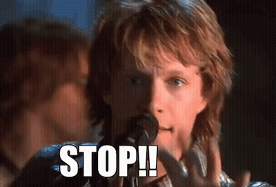 Man With Long Hair Singing Into Microphone While Guitarist Plays On Stage GIF