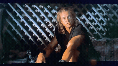 Man With Long Hair Sitting By Fence GIF