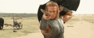 Man With Long Hair Sitting By Fence GIF