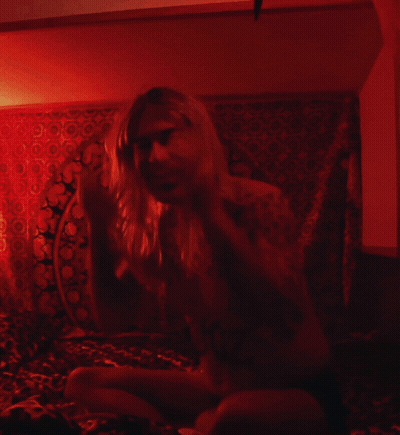 Man With Long Hair Sitting In Dark Room GIF