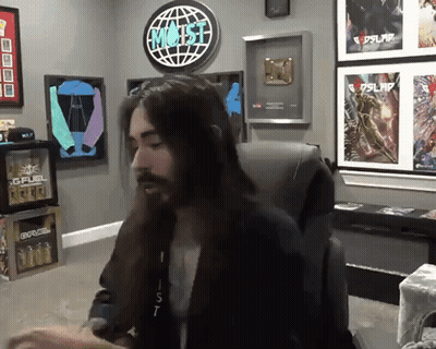 Man With Long Hair Sitting In Front Of Most Sign GIF