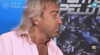 Man With Long Hair Sitting In Front Of Pelot Sign GIF