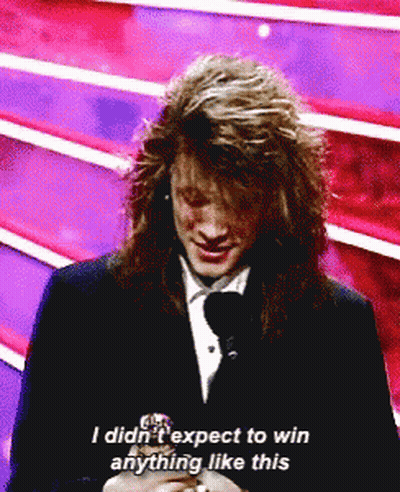 Man With Long Hair Talking Into Microphone Says I Didn't Expect to Win Anything Like This