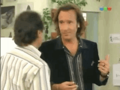 Man With Long Hair Talking To Man In Striped Shirt GIF