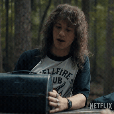 Man With Long Hair Wearing Hellfire Club Shirt GIF