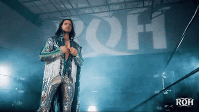 Man With Long Hair Wearing Mask Holding Blue Feather GIF