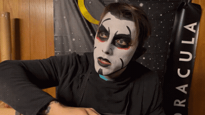 Man With Makeup In Front Of Dracula Banner GIF