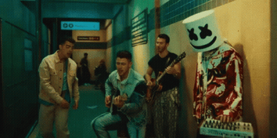 Man With Marshmallow Head Playing Guitar In Hallway GIF