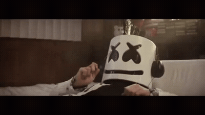 Man With Marshmello Mask And Headphones Lying On Bed GIF