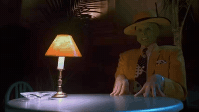 Man With Mask Sitting At Table With Lamp GIF