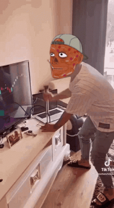 Man With Mask Standing in Front of Laptop and Television