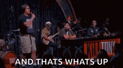 Man With Microphone On Stage With Band And Crowd GIF