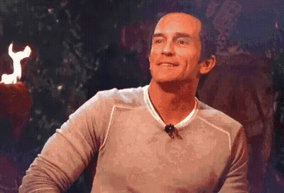 Man With Microphone Smiling In Front Of Fire Torch GIF
