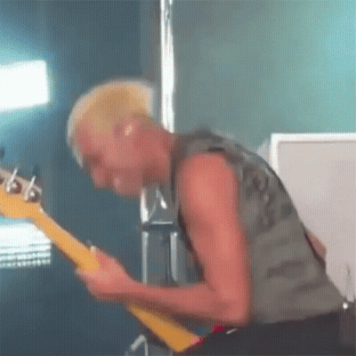 Man With Mohawk Playing Guitar On Stage GIF