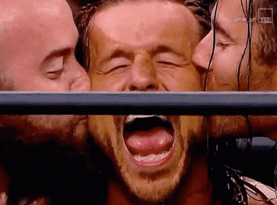 Man With Mouth Open Kissed By Two Men Behind Fence GIF