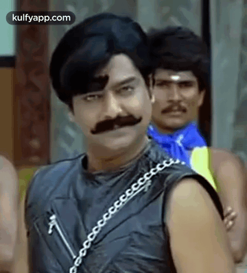 Man With Mustache And Chain Around Neck Standing Next To Another Man GIF