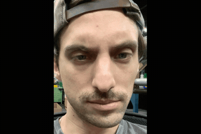 Man With Mustache And Hat Looking At Camera GIF