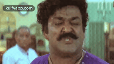 Man With Mustache and Purple Shirt Making Funny Face