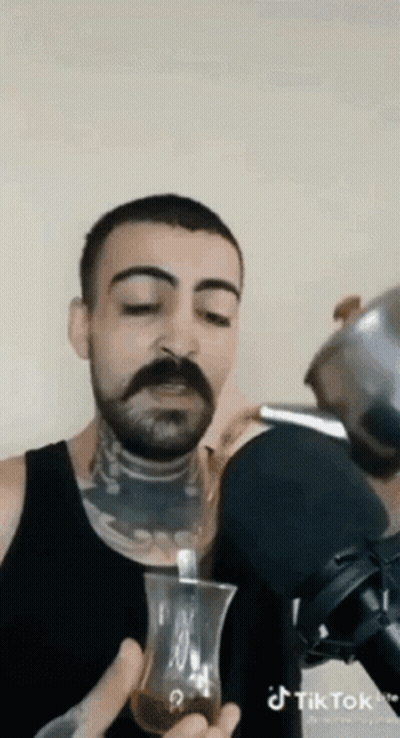 Man With Mustache Drinking From Glass With Spoon GIF