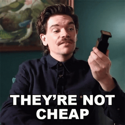 Man With Mustache Holding Cell Phone Saying They're Not Cheap GIF