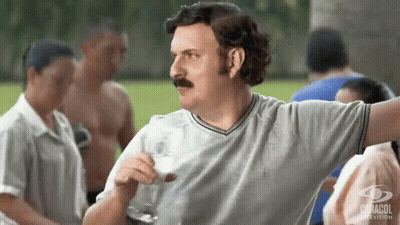 Man With Mustache Holding Glass Of Milk In Front Of Crowd GIF