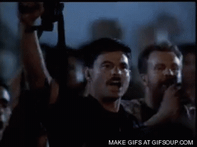 Man With Mustache Holding Gun In Crowd GIF
