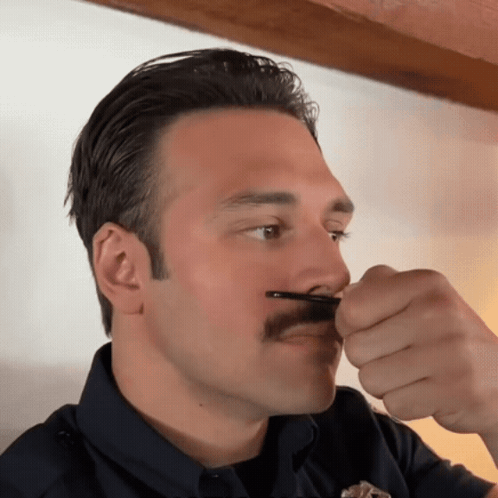 Man With Mustache Holding Something In Mouth GIF